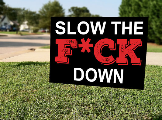 InkBird Print Studio 18x24 vinyl Slow The F*ck Down (censored) yard sign, bold black/red text on white, metal stake in grass curbside.